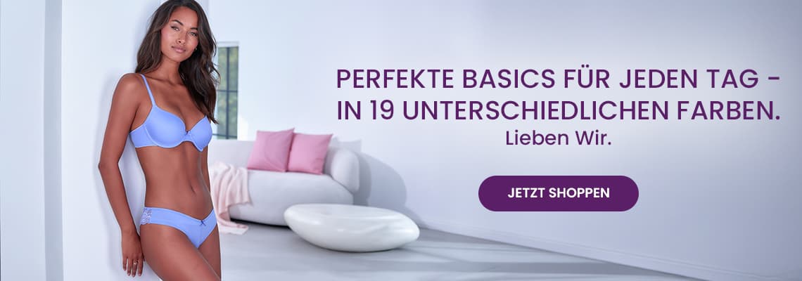 Perfekte Basics für jeden Tag in 19 Farben – Frau in hellblauem BH und Slip steht im modernen Wohnzimmer neben Sofa