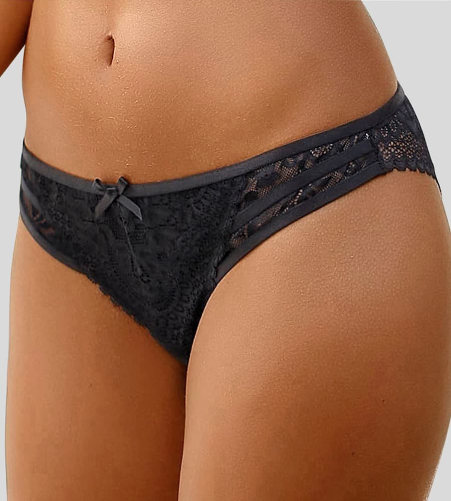 Frau trägt schwarzen Spitzen-Slip, Nahaufnahme der Hüfte und Bauch.