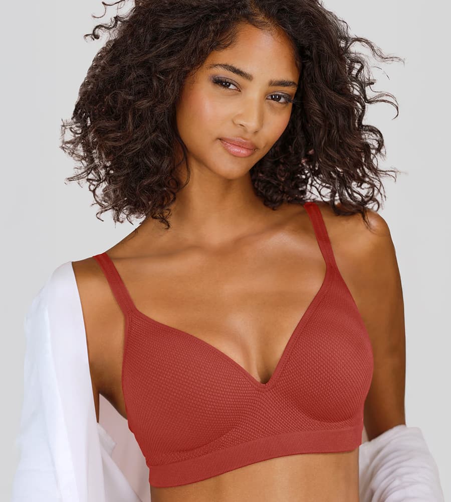 Femme aux cheveux bouclés portant un soutien-gorge rouge, en partie couvert d'une chemise blanche ouverte