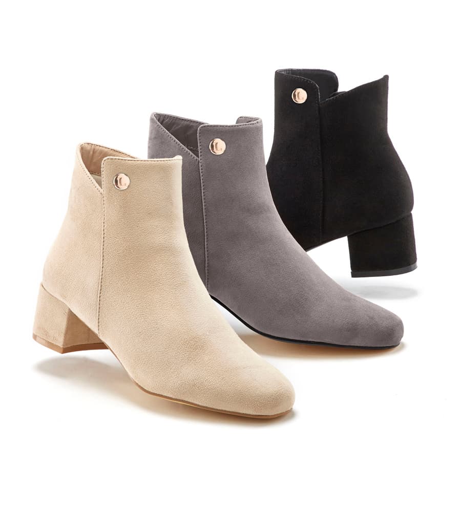 Drei knöchelhohe Stiefeletten mit Blockabsatz in Beige, Grau und Schwarz nebeneinander vor weißem Hintergrund